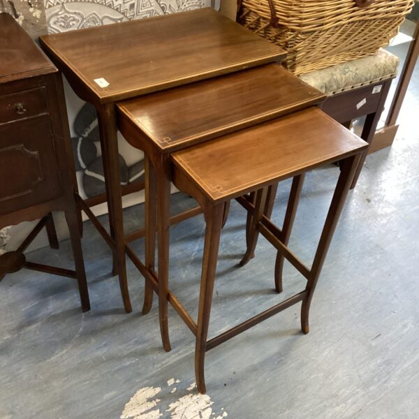 Vintage set of three wood nesting tables in a living room.
