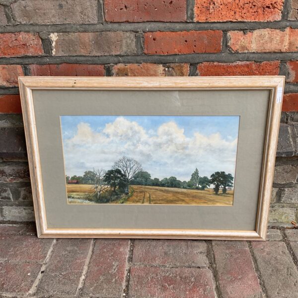Signed watercolour landscape painting with farmhouse and golden fields.