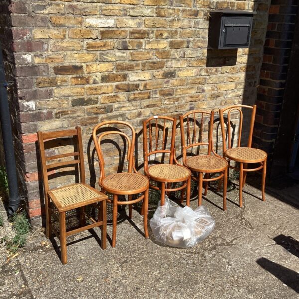 Five vintage rafia dining chairs with spare material.