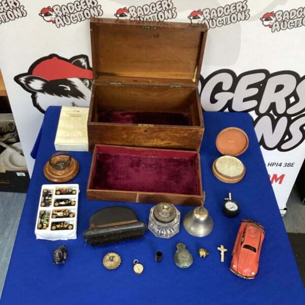 Vintage wooden box filled with antique collectibles and curios.