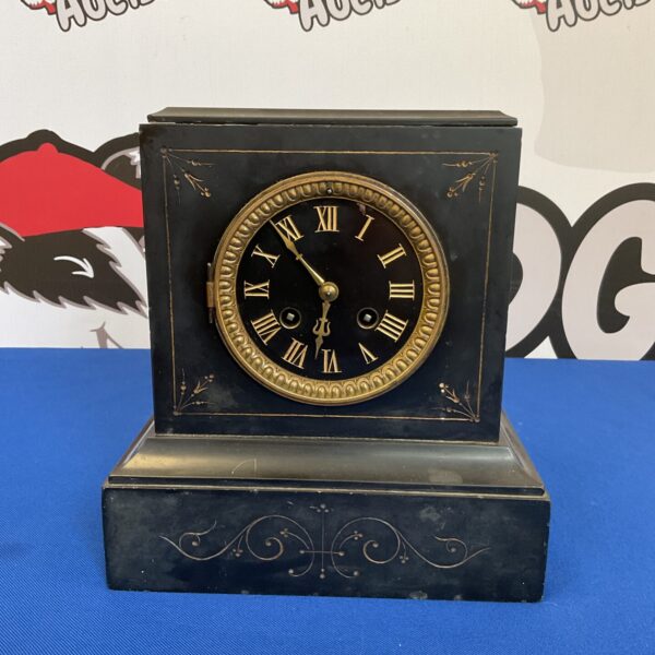 Front view of a dark Victorian slate mantle clock.