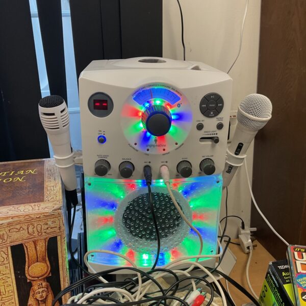 White Singing Machine karaoke system with microphone included.