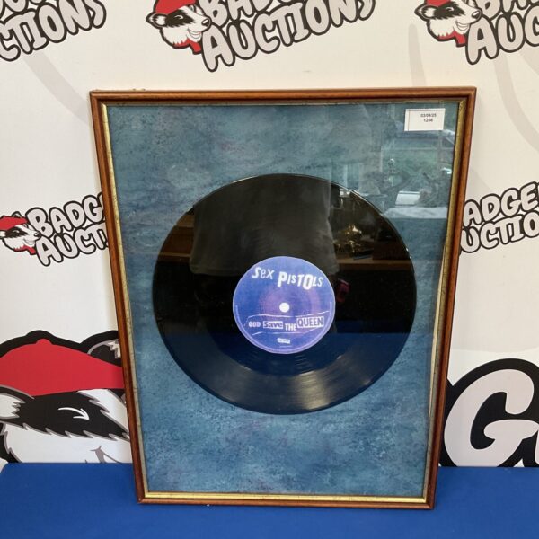 Framed Sex Pistols 12 inch vinyl record for music collectors.
