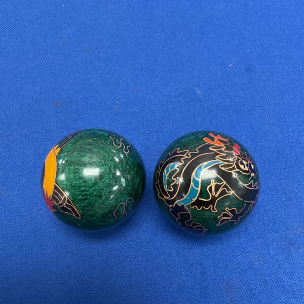 Pair of emerald green Chinese stress balls with dragon designs.