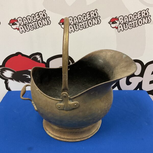 Antique brass coal scuttle with helmet shape and handle.