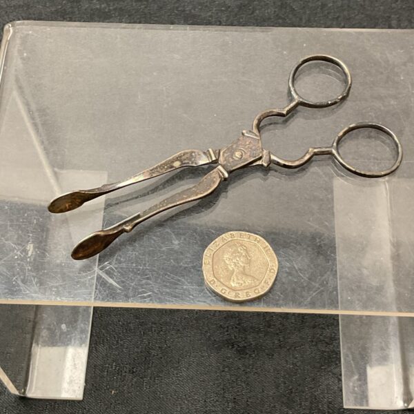 Antique silver plated sugar tongs with pierced design.