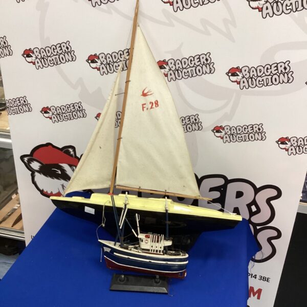 Detailed vintage model yacht with white hull and sail.