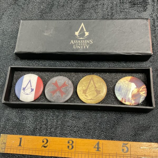 Set of four Assassin's Creed Unity pin badges for collectors.