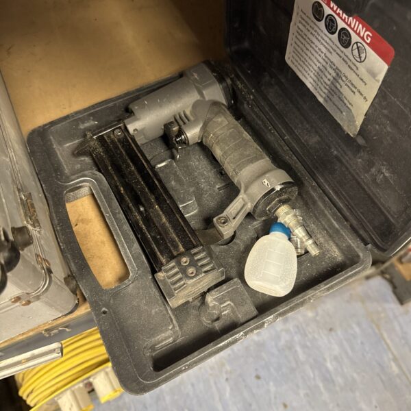 Close-up of vintage pneumatic staple gun for upholstery.