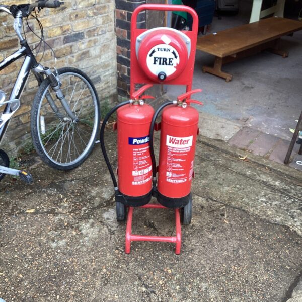 Vintage red portable fire extinguisher station on wheels.