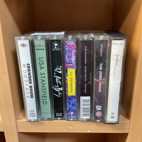 Vintage music cassette collection featuring Tom Jones and U2 tapes.