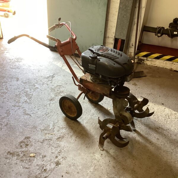 Used Mountfield M23 petrol rotovator for garden soil cultivation.