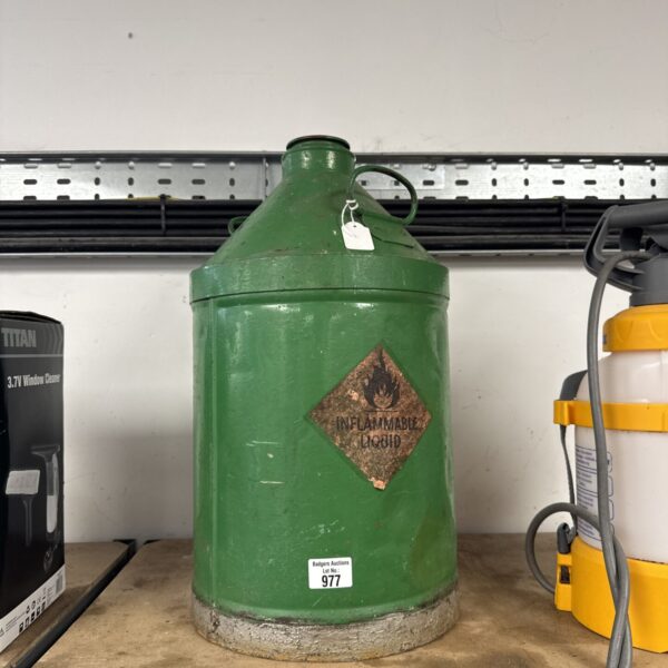 Green vintage fuel can with flammable liquid markings.