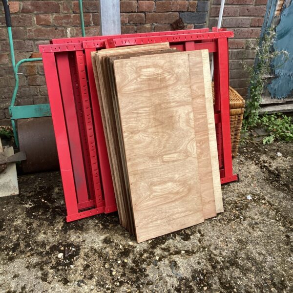 Red heavy duty shelving unit with wooden shelves.