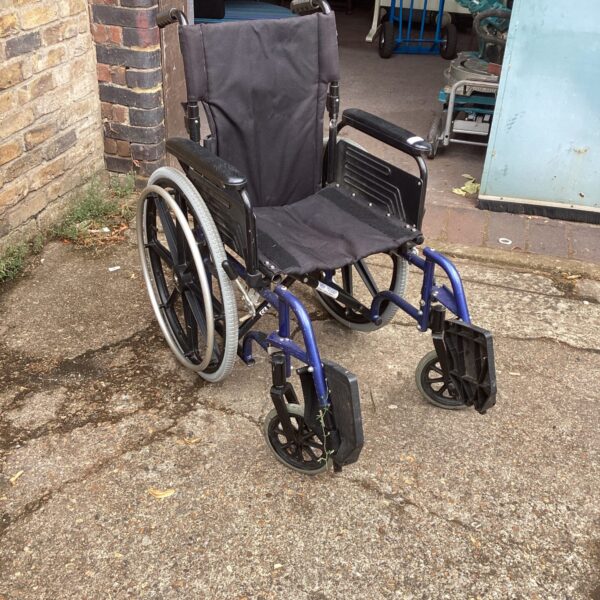 Used Mobility Group folding wheelchair in a garden setting.