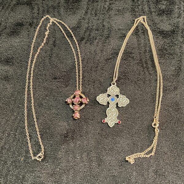 Vintage Celtic cross necklace with red stone detailing on a gold tone chain.