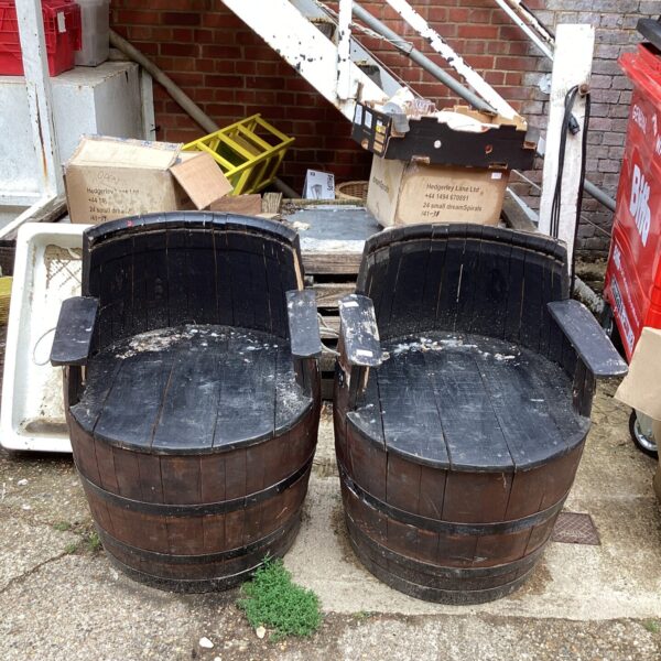 Pair of weathered garden barrel seats in a garden setting.