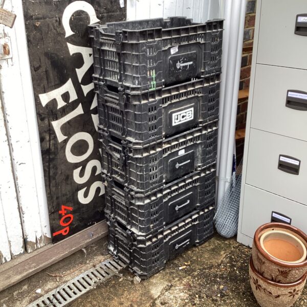Stack of five black plastic storage crates for garage or workshop.