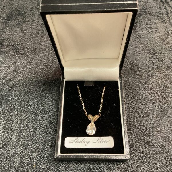Elegant sterling silver pendant necklace with white stone.