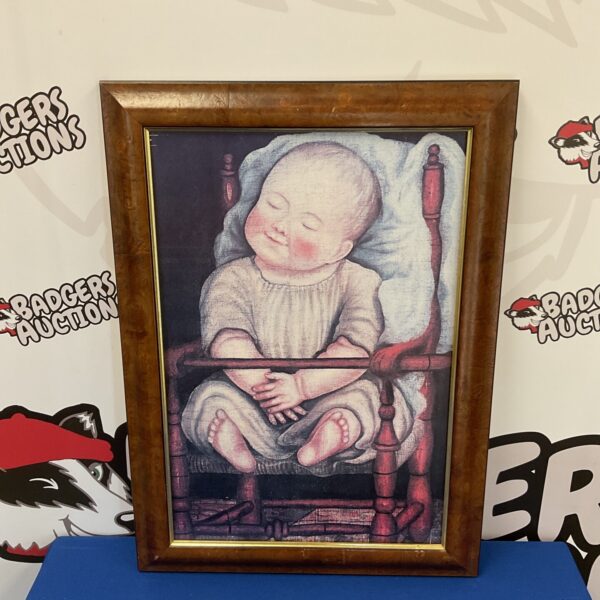 Vintage framed print of a baby in a red chair.