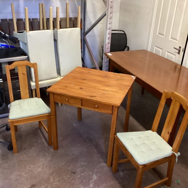 Rustic pine kitchen table and two chairs for farmhouse dining.