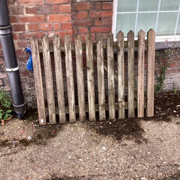 Rustic wooden gate with brackets for garden use.