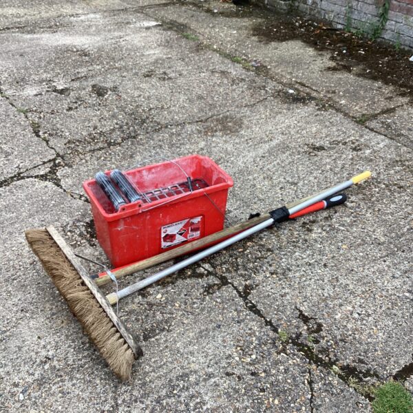 Red cleaning bucket and brush set for professional cleaning.