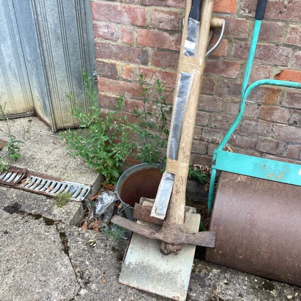 Vintage garden hand tool with metal blade and wooden handle.