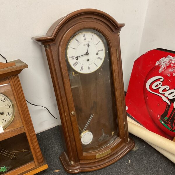 Vintage Hermle German wall clock with pendulum and wooden case.