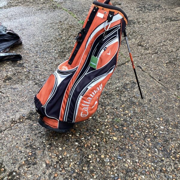 Orange and black Callaway golf bag for carrying clubs.