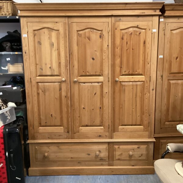 Large three-door pine wardrobe for bedroom storage, vintage style.