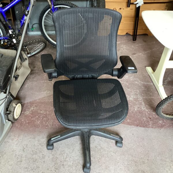 Side view of a black mesh office chair with adjustable height.