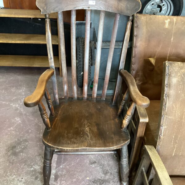 Antique Windsor slat back arm chair with wooden construction.