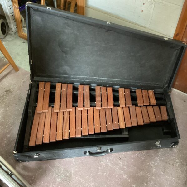 Vintage wooden xylophone inside a black carrying case.