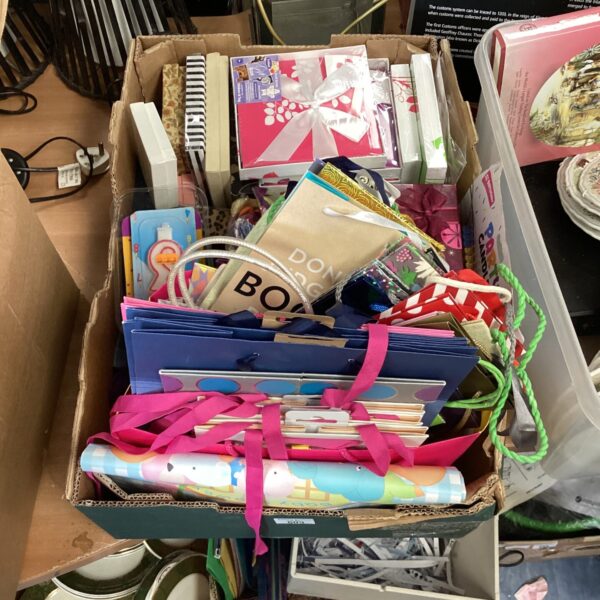Mixed lot of colourful party supplies including gift bags and balloons.