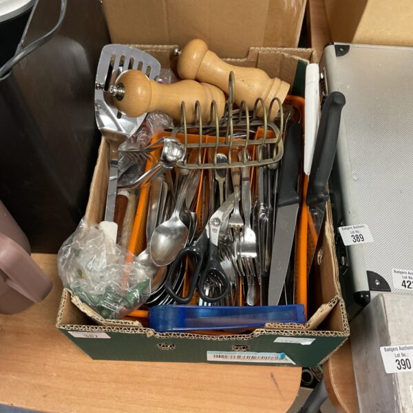 Mixed kitchenware lot with cutlery and salt shakers on display.