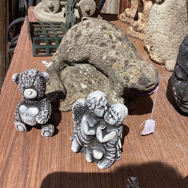 Garden ornament lot featuring otter, cherub and bear statues.