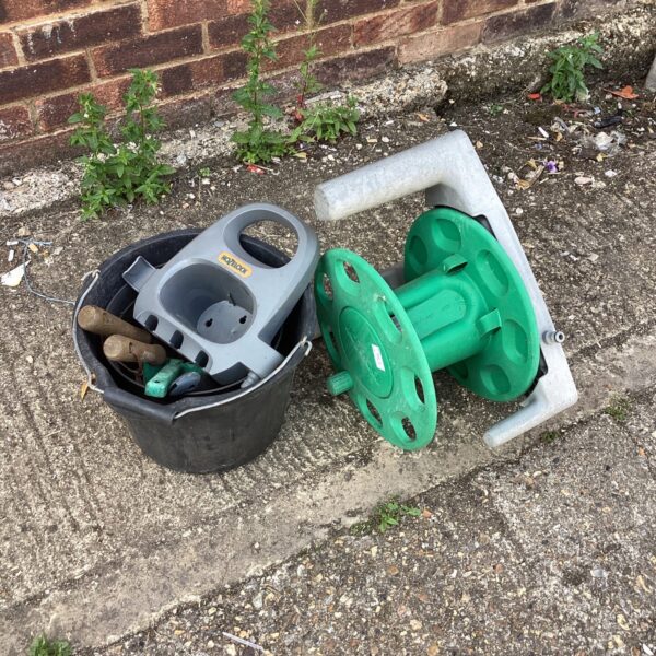 Garden tool lot featuring a Hozlock hose reel and watering can.