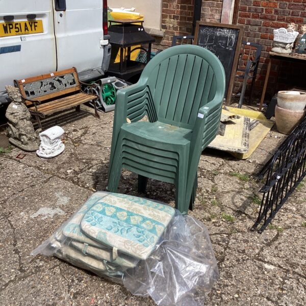 Lot of six plastic garden chairs with cushions for outdoor use.