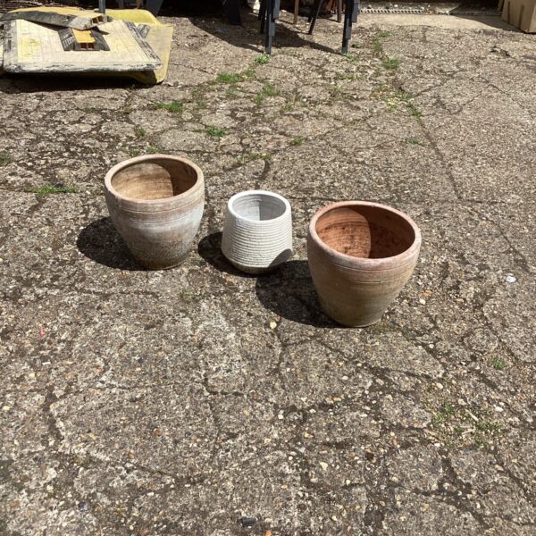 Lot of three rustic terracotta garden planters for outdoor use.