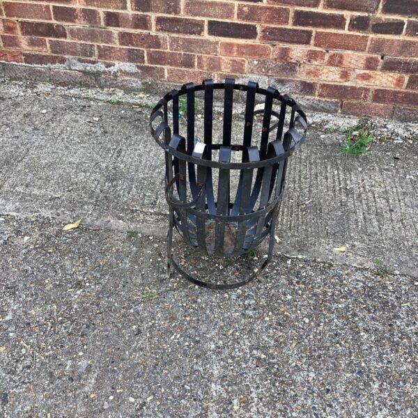 Rustic metal garden fire basket for outdoor heating and ambiance.