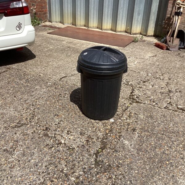Black plastic garden bin in an outdoor setting.