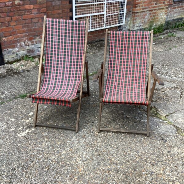Vintage deckchair pair in a garden setting.