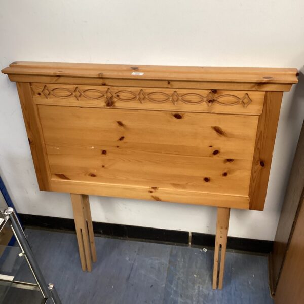 Vintage pine headboard with decorative detailing.