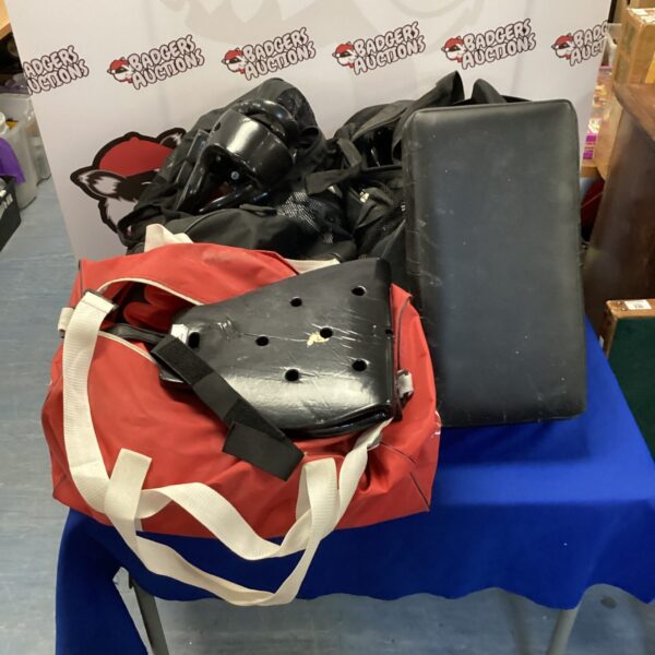 Black martial arts pads with adjustable straps for training.