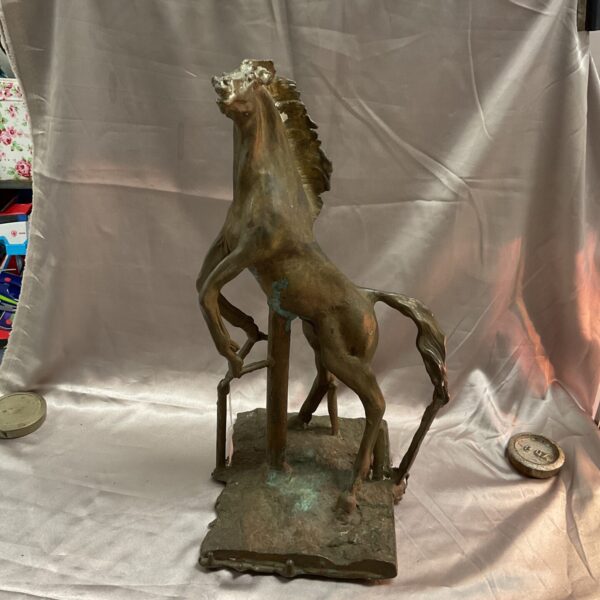 Large bronze rearing horse sculpture on display.