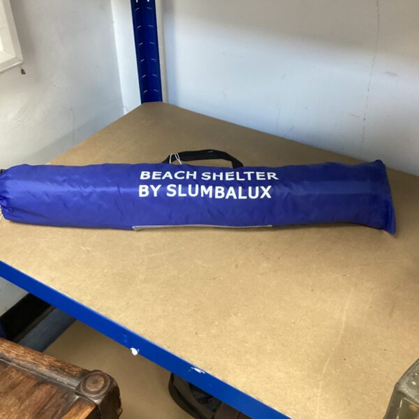 Collapsed portable beach shelter, a pop-up sun shade tent.