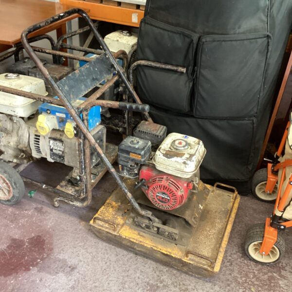 Side view of a used Wacker plate compactor for construction.