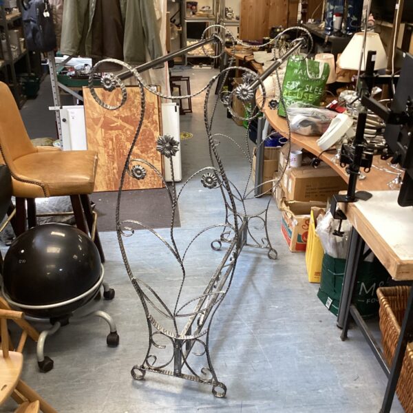 Vintage wrought iron decorative clothes rail for clothing display.