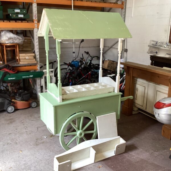Vintage green market trader barrow with fixed wheels.